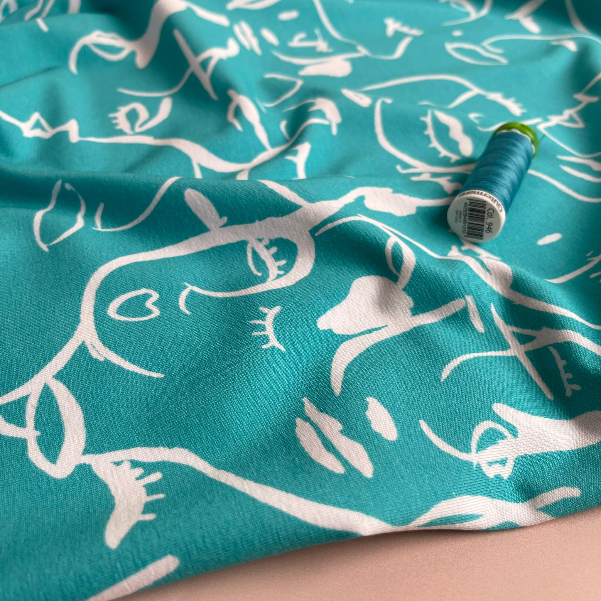 Danish Design - Painted Faces on Turquoise Cotton Jersey Fabric