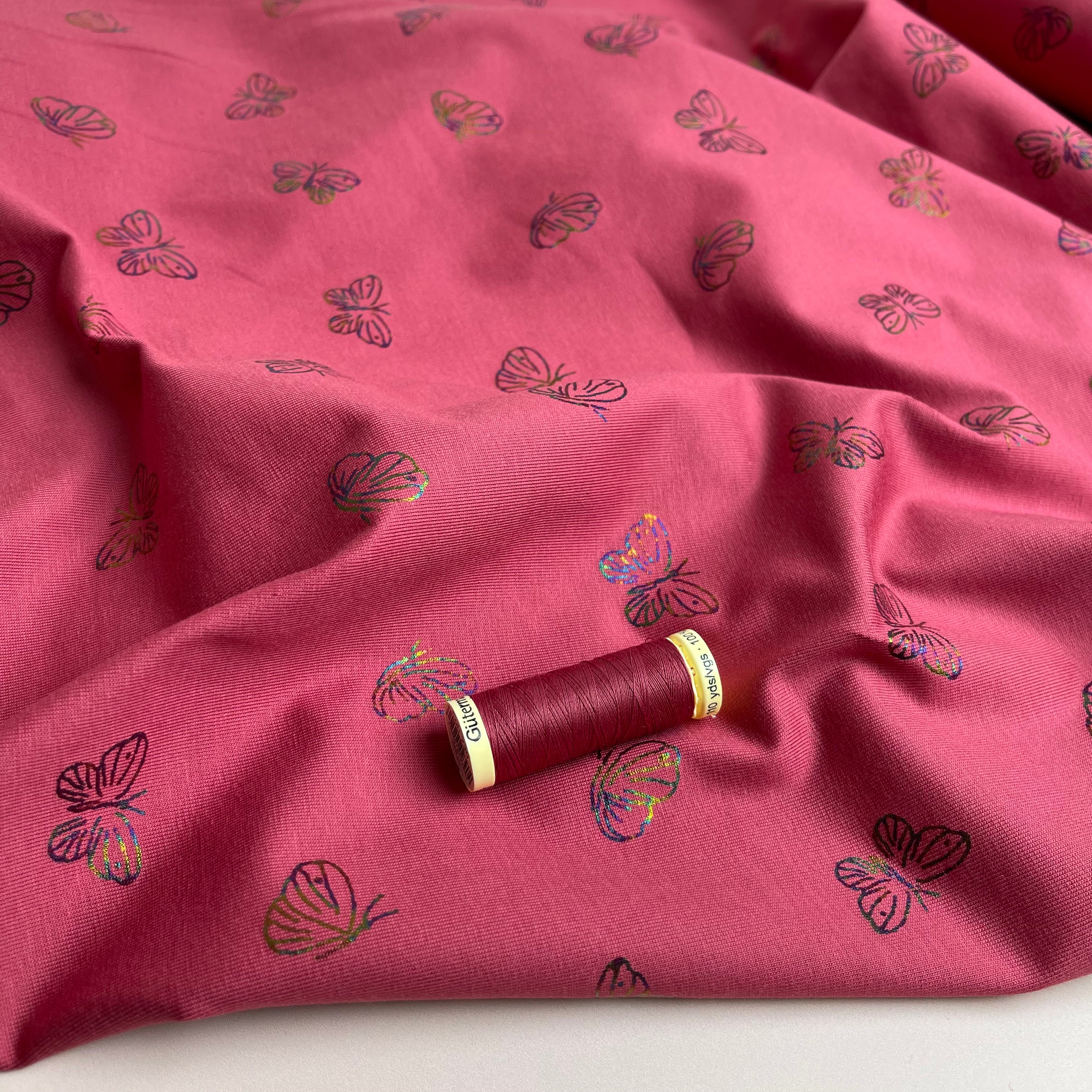 Rainbow Butterflies on Raspberry Cotton Jersey Fabric