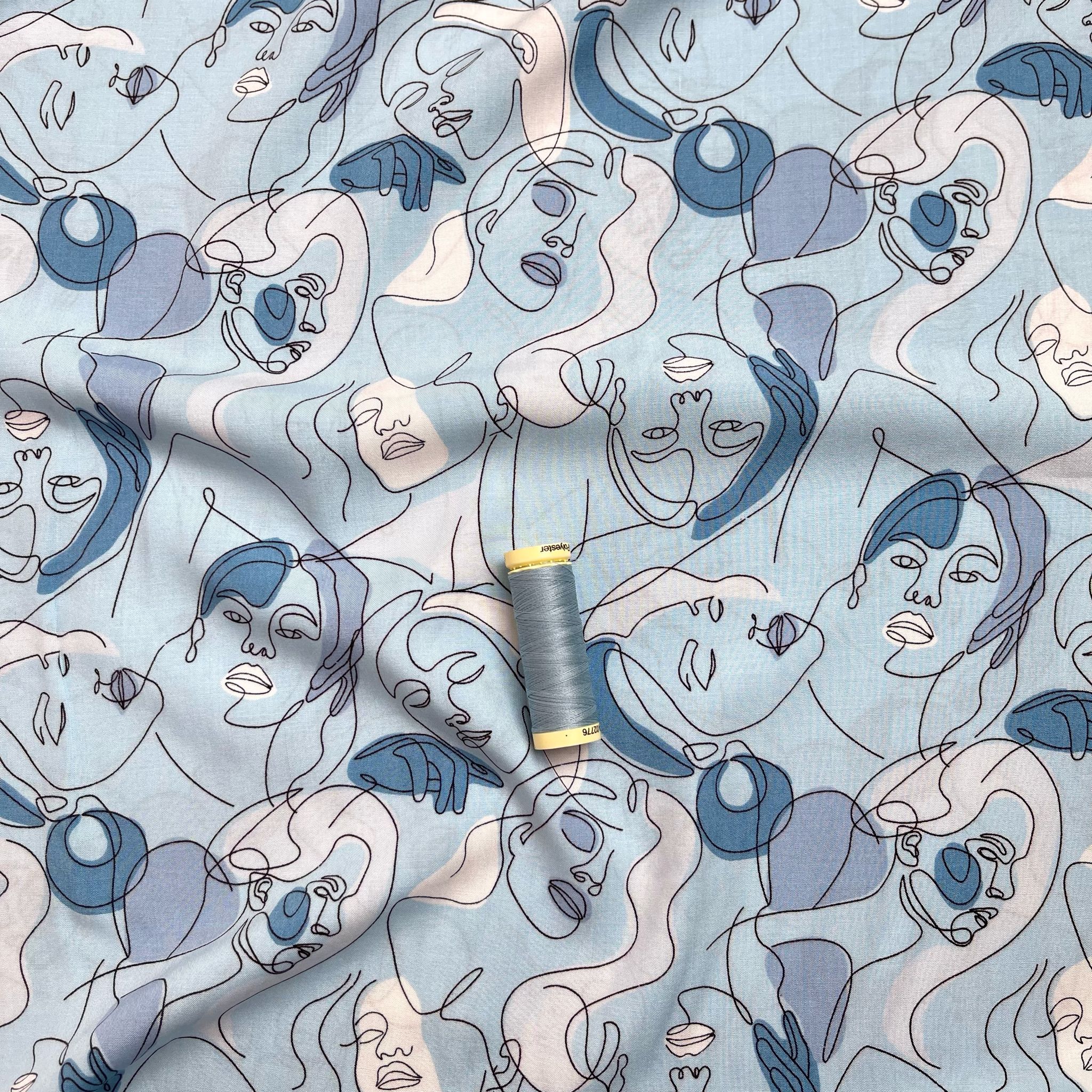 Faces on Turquoise Blue Viscose Fabric