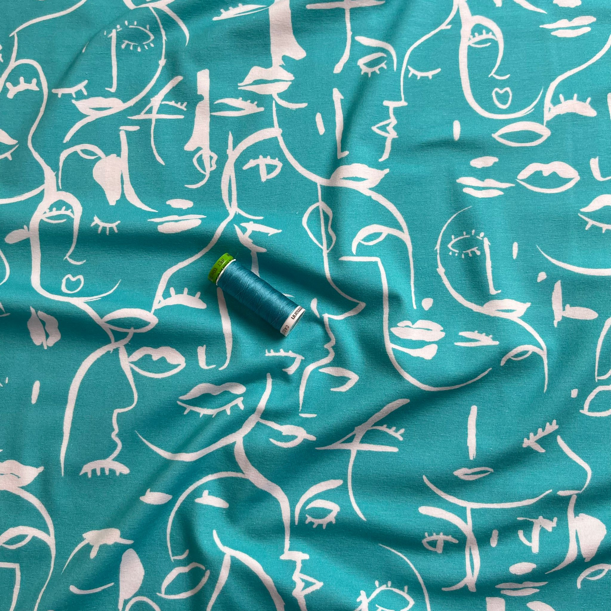 REMNANT 2.33 Metres - Danish Design - Painted Faces on Turquoise Cotton Jersey Fabric