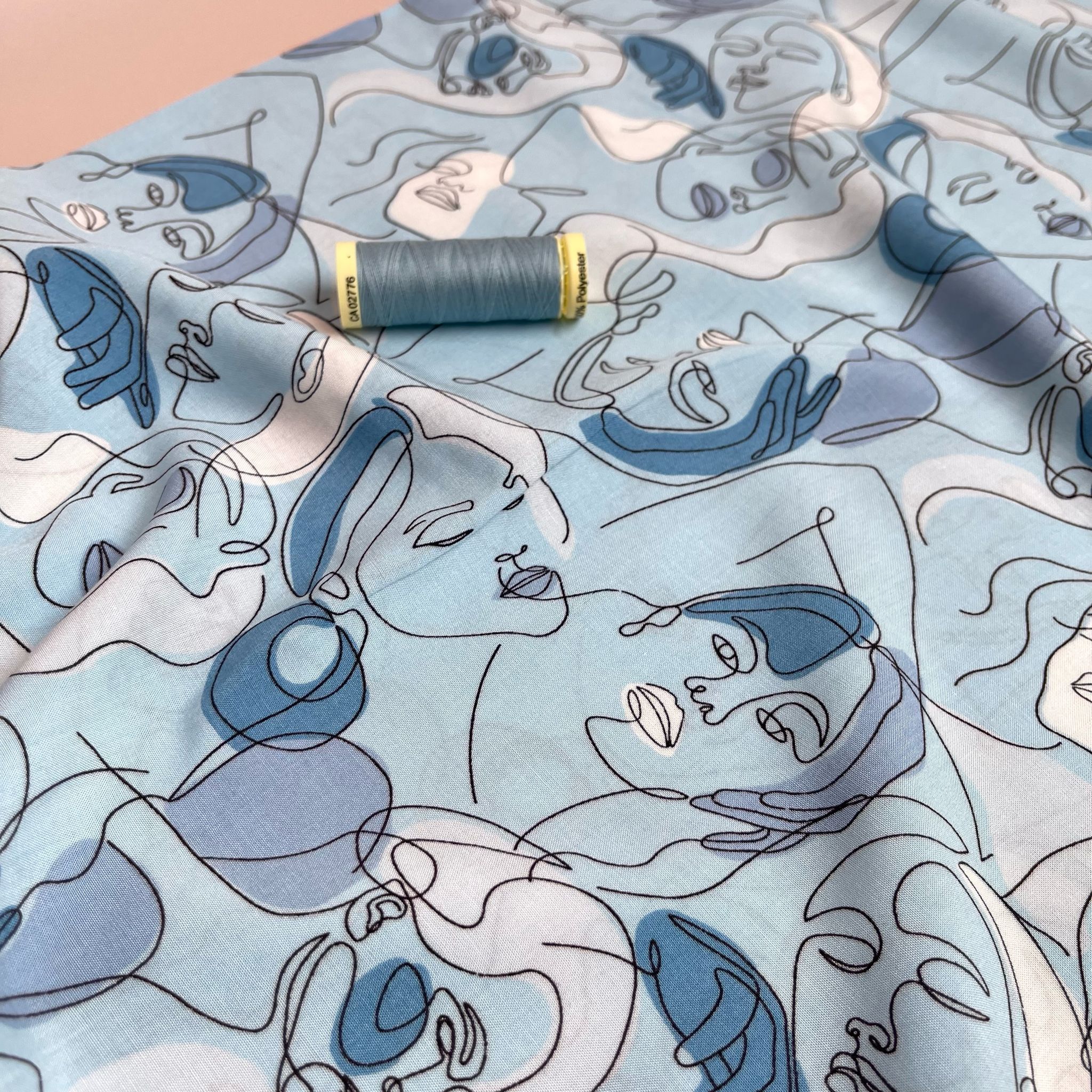 Faces on Turquoise Blue Viscose Fabric