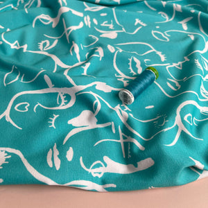 REMNANT 0.69 Metre - Danish Design - Painted Faces on Turquoise Cotton Jersey Fabric