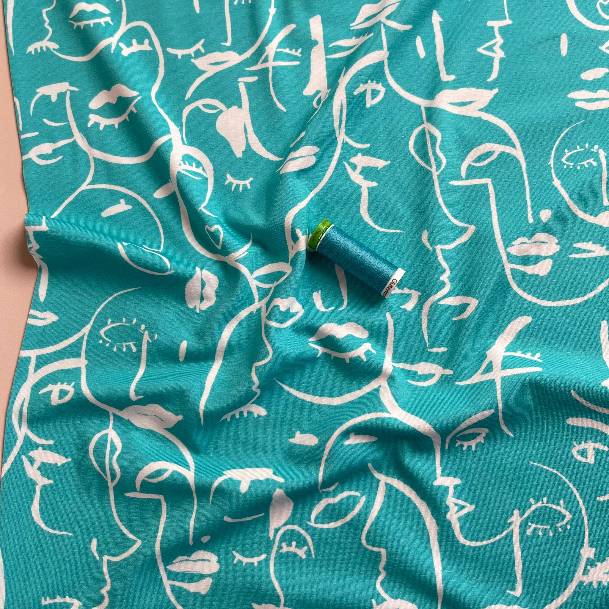 REMNANT 0.69 Metre - Danish Design - Painted Faces on Turquoise Cotton Jersey Fabric